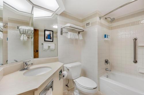 a bathroom with a sink and a toilet and a tub at Pear Tree Inn Cape Girardeau West in Cape Girardeau