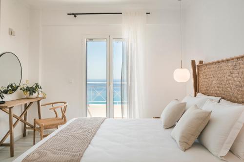 a bedroom with a bed with a view of the ocean at Lourdas White Villa in Kefallonia