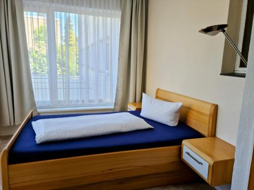 a bed in a room with a large window at Hotel Süden in Berlin