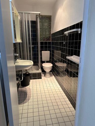 a bathroom with a toilet and a sink at Hotel Süden in Berlin