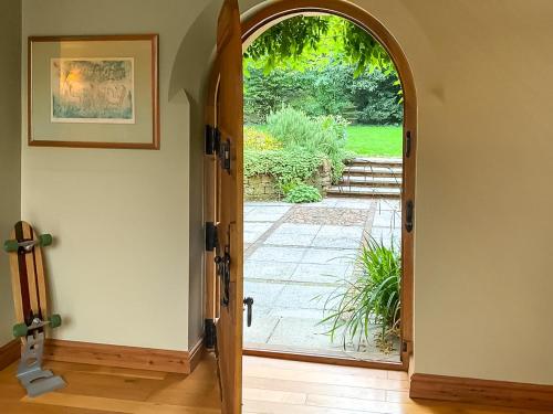 an open door to a garden with a patio at Church Barn in Olney