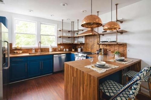 a kitchen with blue cabinets and a wooden island at Parkfront Lux in Atlanta
