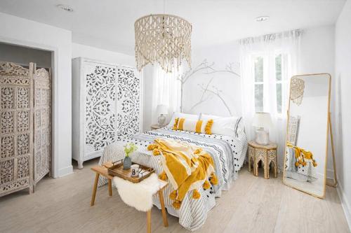 a white bedroom with a bed and a chandelier at Parkfront Lux in Atlanta