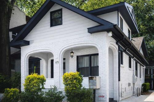 a white house with a black roof at Parkfront Lux in Atlanta