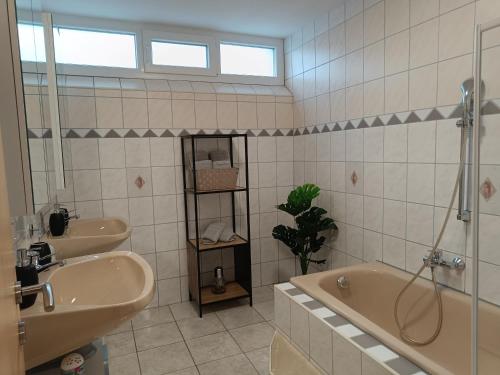 ein Badezimmer mit Badewanne, Waschbecken und Dusche in der Unterkunft Ella Ferienwohnung in Arnoldstein