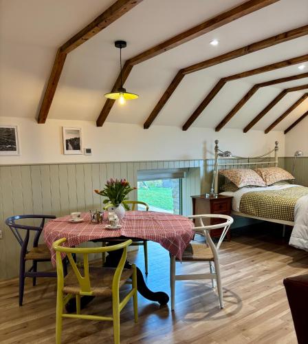 a dining room with a table and chairs and a bed at Foyle View Glebe Barn in Tullyverry