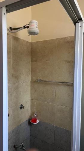 a bathroom with a shower with a sink and a light at Emerald Tulivu Place in Ruaka