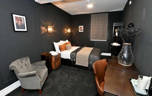 a bedroom with a bed and a chair and a table at The Royal Keep Hotel in Dudley in Dudley