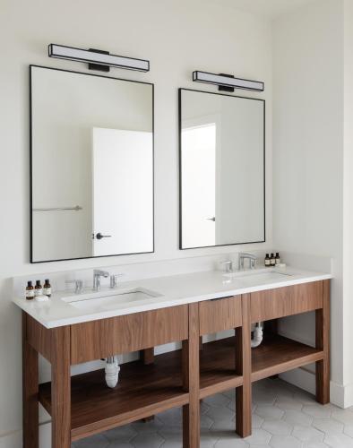a bathroom with two sinks and two mirrors at Roost Baltimore in Baltimore