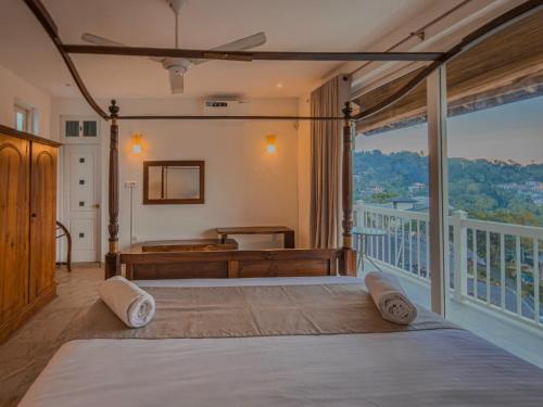 a bedroom with a large bed and a balcony at Nature Breeze Boutique Villa in Kandy