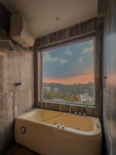 a bath tub in a bathroom with a window at Nature Breeze Boutique Villa in Kandy