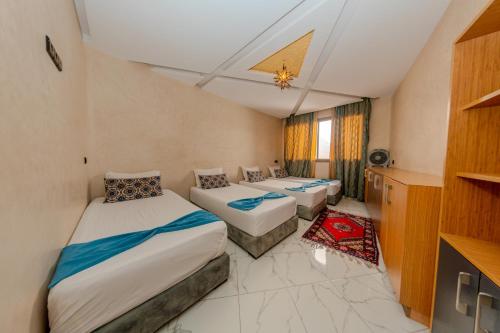 a hotel room with two beds and a tv at Route de Miel in Agadir