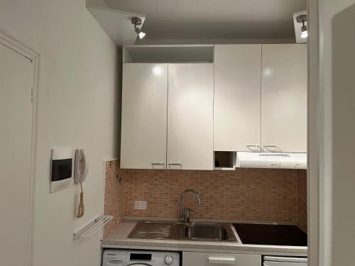 a kitchen with white cabinets and a sink at Oasi di pace in Domaso