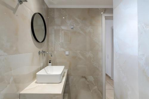 a white bathroom with a sink and a mirror at Villa Dimi in Tsilivi