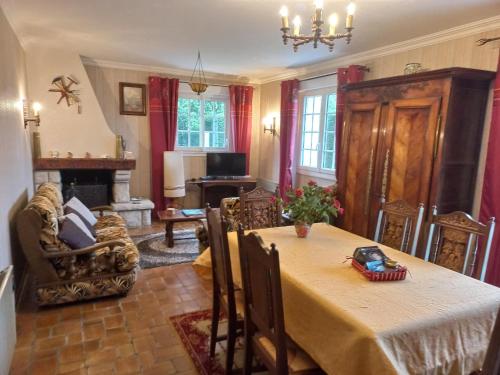 a dining room with a table and a fireplace at Charming Breton house in Hénansal in Hénansal