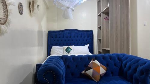 a blue tufted bed with a blue headboard in a bedroom at Emerald Tulivu Place in Ruaka