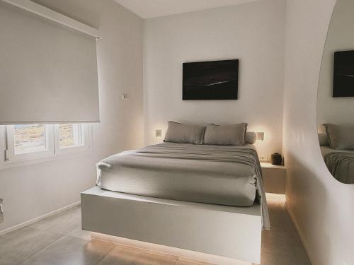 a white bedroom with a bed in a room at AELIA Tinos in Tinos