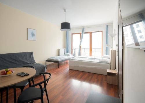 a living room with a couch and a table at Rooms Green Rydygiera 17 own private room tv wifi in Warsaw