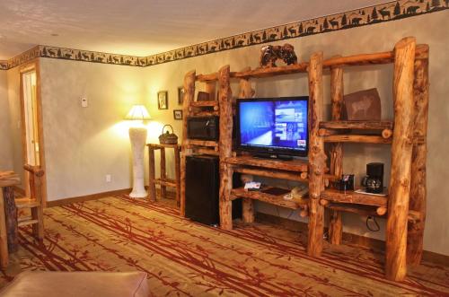 a living room with a tv and wooden shelves at Gateway Inn and Suites in Salida