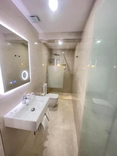 a bathroom with a sink and a toilet and a mirror at Hotel Flamingo in Lisbon