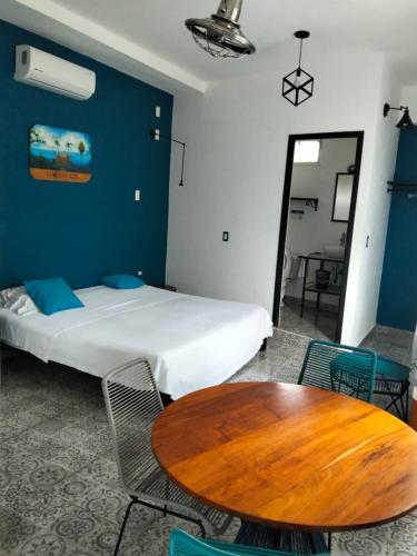 a bedroom with a bed and a table and chairs at Hostal Estancia del Agua in Xul-Ha