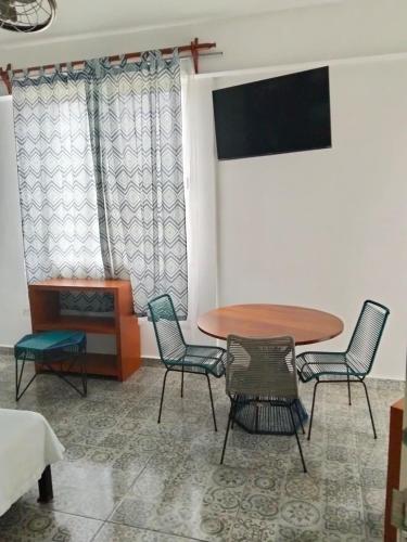 a room with a table and chairs and a tv at Hostal Estancia del Agua in Xul-Ha