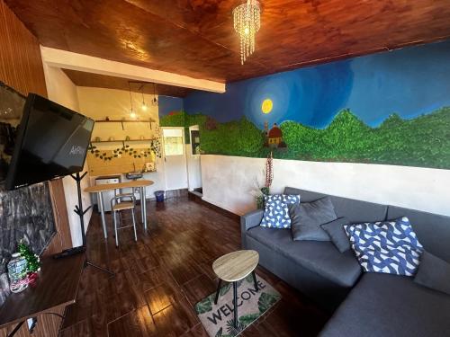 a living room with a couch and a tv at El Refugio del Viajero in Mineral del Chico