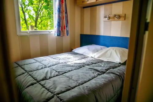 a bed in a small room with a window at Camping Parc Bellevue - Maeva in Cannes