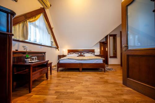 a bedroom with a bed and a desk and a window at Pension Brasovu Vechi in Braşov