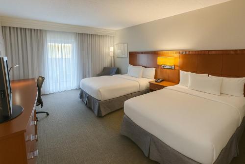 a hotel room with two beds and a television at Hotel Preston by IHG in Montgomery