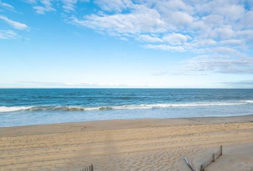 a sandy beach with the ocean in the background at Fly Boys - Nags Head MP 12.5, Oceanfront, Ocean View, Elevator, Pool Table, Hot Tub, YR Flex in Nags Head