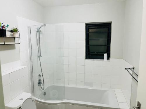 a white bathroom with a shower and a toilet at Valley Escape in Cape Town