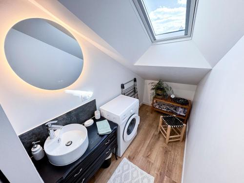 a bathroom with a sink and a mirror at La Maisonnette de Carreaux in Azay-le-Rideau