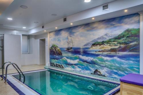 a swimming pool with a large painting on the wall at Elbrus Hotel in Cheboksary