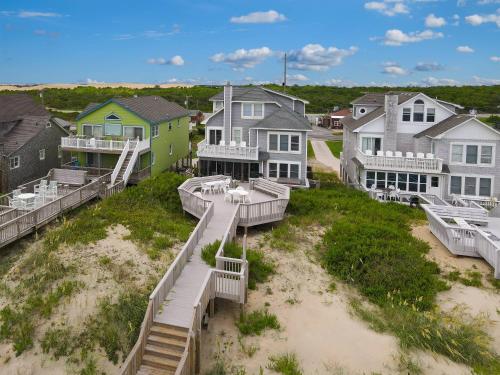 a group of houses on the beach with acean at Dunes for Days - Nags Head MP 12.5, Oceanfront, Hot Tub, Rec Room, Pets OK, YR Flex in Nags Head