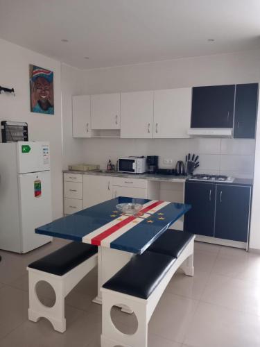 een keuken met een blauwe tafel en witte kasten bij Bellamy in Porto Novo