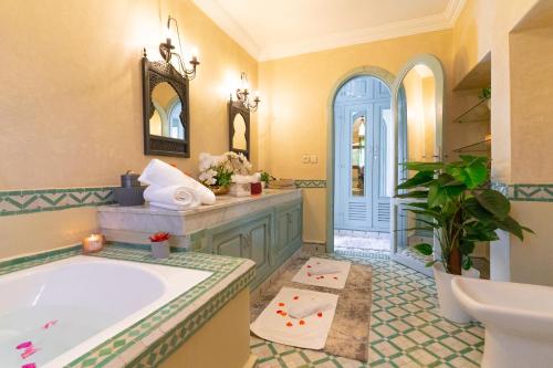 a large bathroom with a tub and a sink at Palais les sources de l'atlas, Padel & spa in Marrakesh
