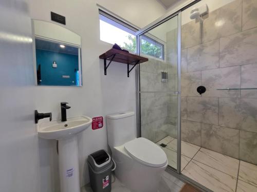 a bathroom with a shower and a toilet and a sink at Ocean Breeze at Life's a Beach in Uvita