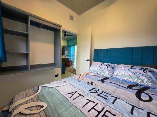 a bedroom with a large bed with a blue headboard at Ocean Breeze at Life's a Beach in Uvita