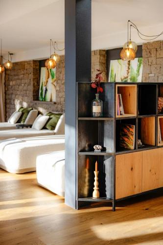 a living room with a bed and a book shelf at Hotel Der Waldhof in Vollan