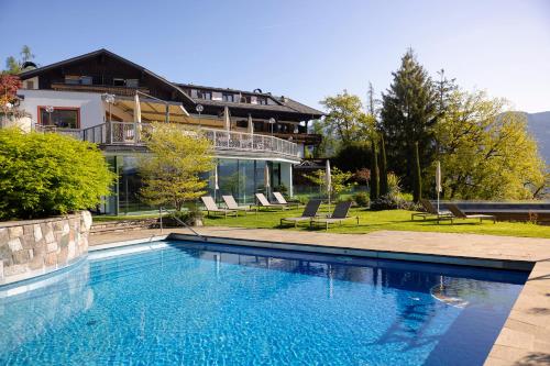 a large swimming pool in front of a house at Hotel Der Waldhof in Vollan