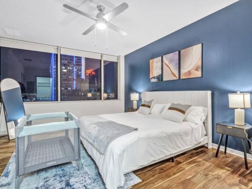 a bedroom with a large bed and a blue wall at Luxury Apt W/Parking CityView|Pool| Gym|PoolTable in Dallas