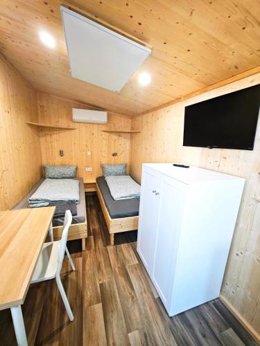 a room with a refrigerator and a table and a tv at Tiny Guesthouse Euerbach in Euerbach