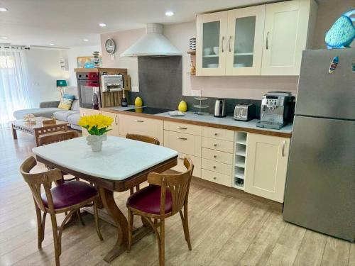 Appartement chic في Saint-Génis: مطبخ مع طاولة وكراسي وثلاجة