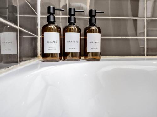 four bottles of wine sitting on a sink at Luxury Apt W/Parking CityView|Pool| Gym|PoolTable in Dallas