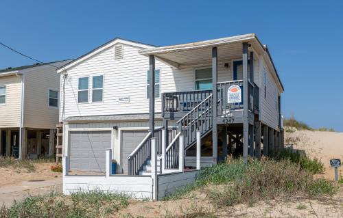 a house with a porch and a staircase in front of it at Aqua Moon - Kitty Hawk MP 3, Oceanfront, Family Friendly, Hot Tub in Kitty Hawk