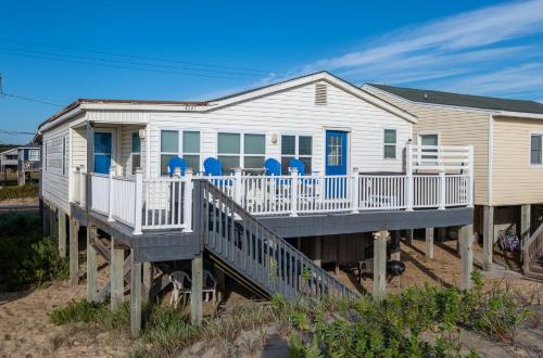 a house on a dock with blue chairs on it at Aqua Moon - Kitty Hawk MP 3, Oceanfront, Family Friendly, Hot Tub in Kitty Hawk
