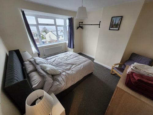 a bedroom with a bed and a couch and a window at Bank End Cottage in Almondbury