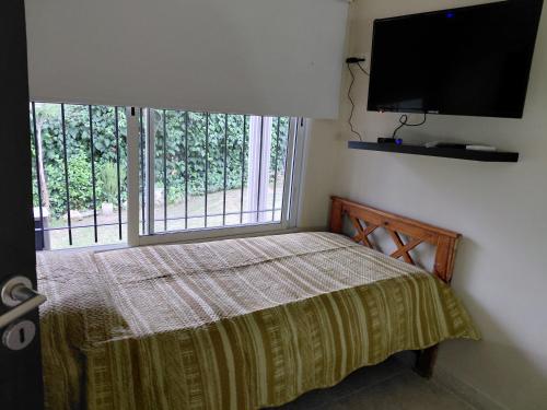 a bedroom with a bed and a flat screen tv at La tranquera ll in Trapiche