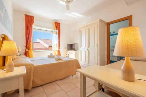 a bedroom with a bed and a window at A.I.R. Hotel Gabbiano in Isola Rossa